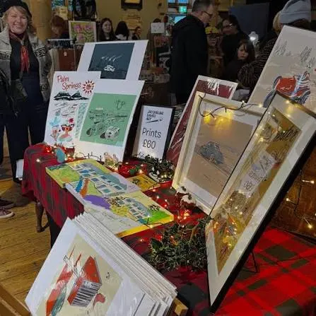A print stall with framed prints and fairy lights