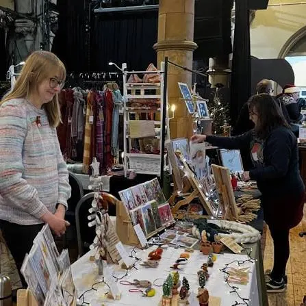 A maker at a stall of knitted and crafted gifts