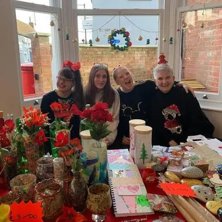 Four makers behind a stall of handmade gifts and flowers